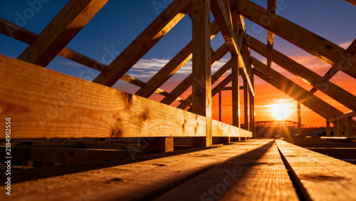 Wooden roof trusses of a house under construction at sunset