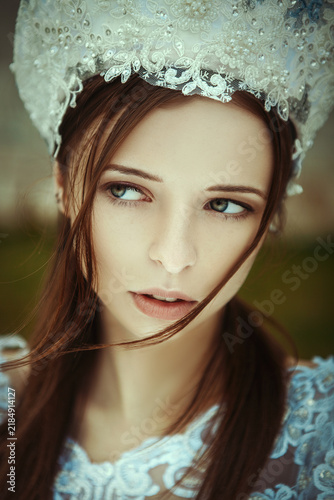 Young Woman in Traditional Russian Attire Standing by Red Brick Fortress Wall