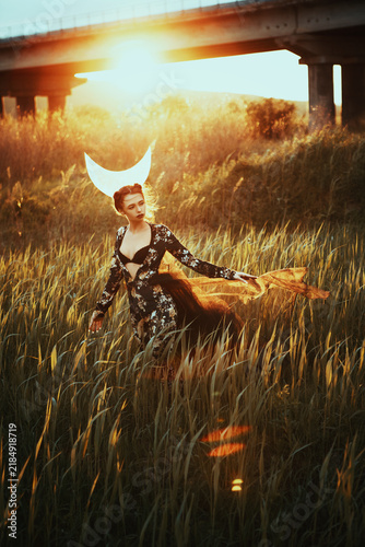 Gothic Woman with Moon Headpiece Standing in Ruined Stone Structure