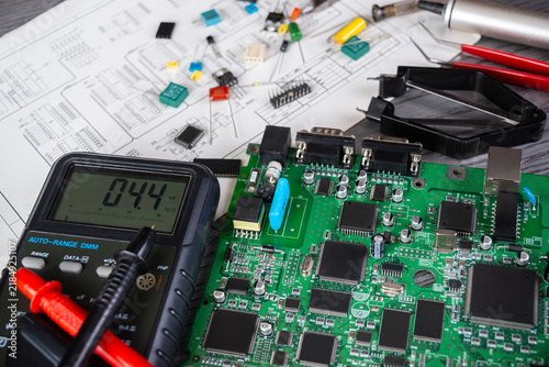 Canvas Print Working on a circuit board with multimeter and various components on a work tabl
