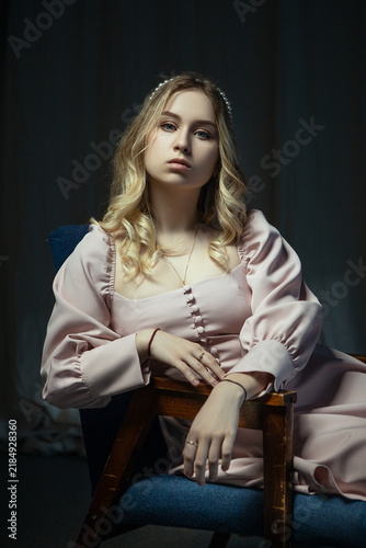 Young Woman in Pink Dress Sitting on Blue Armchair