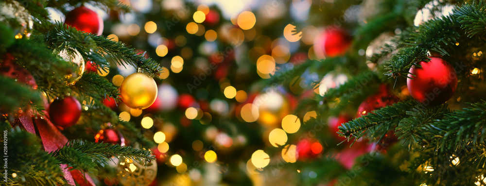 Obraz premium beautiful classic Christmas background. festive decorations, red and golden balls, glowing garlands on christmas tree. Symbol of winter season, New Year, Christmas holiday. banner. Template for design