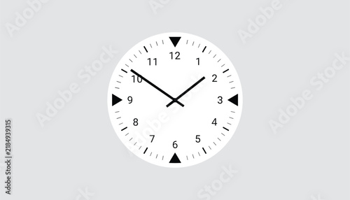 Minimalist white wall clock showing ten past ten with black hands and triangle markers at quarter hour positions.
