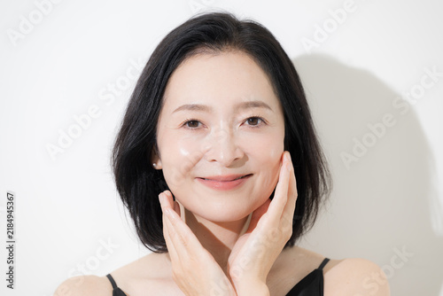 Obraz na płótnie A beauty portrait of a woman in her 50s with beautiful skin, laughing heartily;