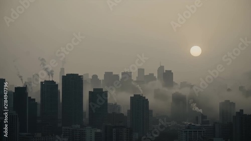 City Skyline Emerging Through Thick Smog with Pale Sun in Hazy Atmosphere