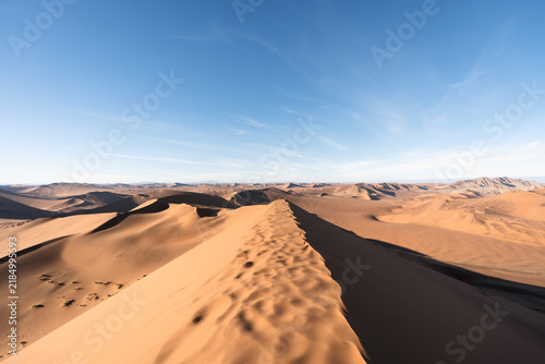 Foto Footprints running along a narrow dune ridge