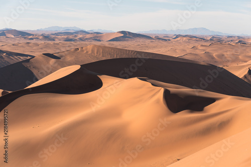 фотографія Sea of dunes stretching to distant mountains