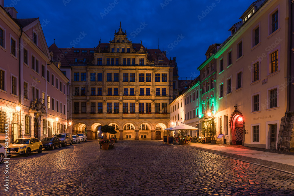 Fototapeta premium Stunning night cityscape of Görlitz, Germany. Beautifully illuminated historic Old Town, medieval architecture, and bright street lights highlighting the rich cultural heritage at dusk.