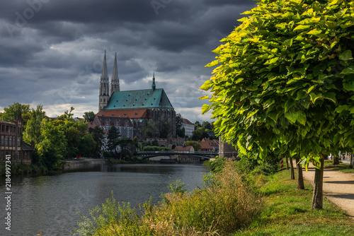 Scenic daytime view of historic Görlitz, Germany. Beautiful cityscape featuring medieval Old Town architecture, cobblestone streets, colorful facades, and the Peterskirche in bright summer sunlight.