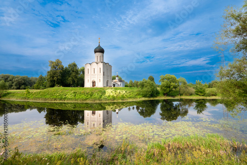 Foto Church of the Intercession on the Nerl with Reflection in River Surrounded by Tr