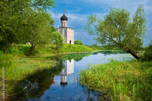 Fotografía Church of the Intercession on the Nerl with Reflection in River Surrounded by Tr