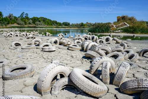 Canvas Print A dry riverbed is littered with countless abandoned tires, suggesting an environmental concern