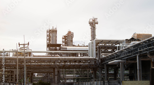 Foto Petrochemical plant with distillation towers and pipe racks against bright sky