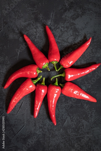 Foto Circle of hot chili peppers on a dark stone background