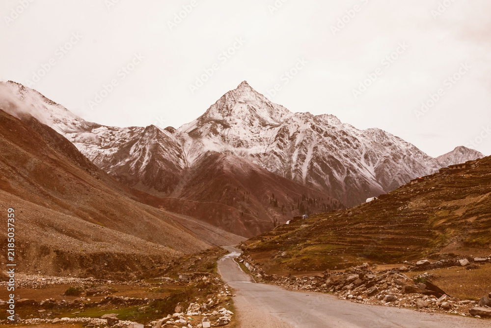 Obraz premium Scenic mountain road with snow-capped peaks