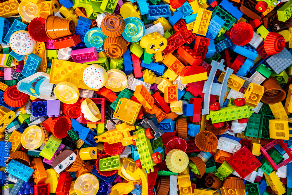 Obraz premium Top view A pile of multicolor of many Lego toy blocks in various shapes and different sizes. Toys and games. Leisure and recreation.
