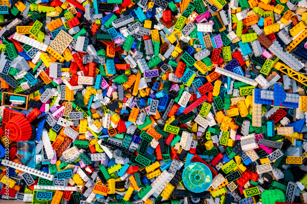 Obraz premium Top view A pile of multicolor of many Lego toy blocks in various shapes and different sizes. Toys and games. Leisure and recreation.