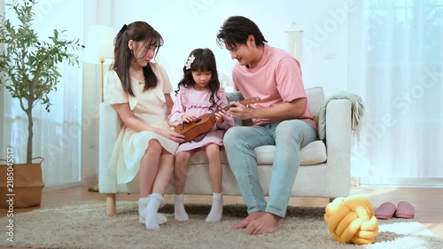 Family Enjoys Time Together While Playing Music in Their Living Room