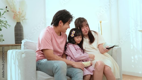 Family Enjoys Watching Television Together in a Cozy Living Room During the Afternoon