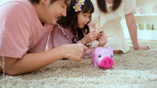 Family Spends Time Together Teaching Kids About Saving Money With a Piggy Bank