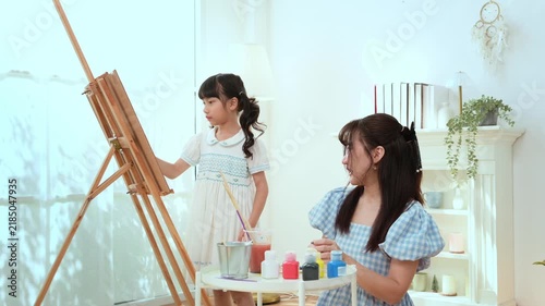 Girl Learns Painting With Mom in a Bright Room During the Afternoon Hours