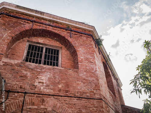 Photography Weathered Brick Facade with an Arched Window on a Historic Building