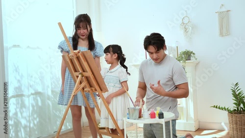 Girl Paints With Family in Home as They Enjoy Creative Education Time Together