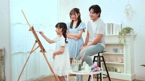Girl Paints With Family in Home as They Enjoy Creative Education Time Together