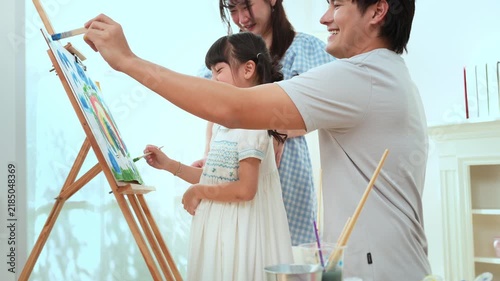 Girl Paints With Family in Home as They Enjoy Creative Education Time Together
