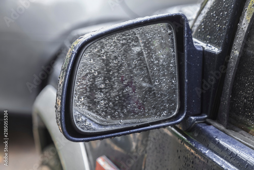 Quadro su tela Raindrops cling to a car's side mirror
