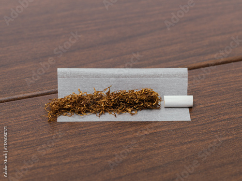 Loose Tobacco and Filter on Rolling Paper over Wooden Surface