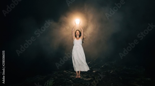 Woman Holding Light in Darkness