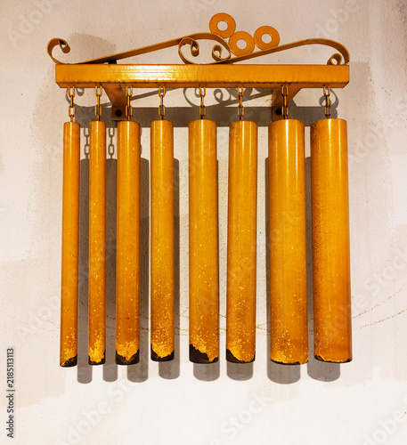 Fotografie Yellow steel decoration chimes, percussion instrument mounted on a wall