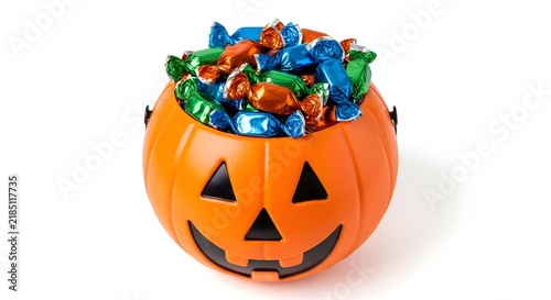 Halloween pumpkin bucket filled with wrapped candy isolated on white background