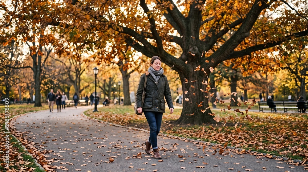 Fototapeta premium Autumn Leaves Falling Around Pedestrian in City Park Generative AI