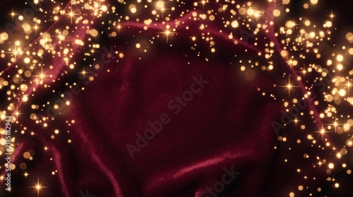 Glowing gold bokeh stars on deep burgundy red velvet background
