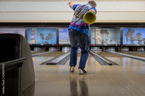 Obraz na płótnie Low-Angle View Down a Polished Bowling Lane Toward the Pins as a Bowler Steps Up