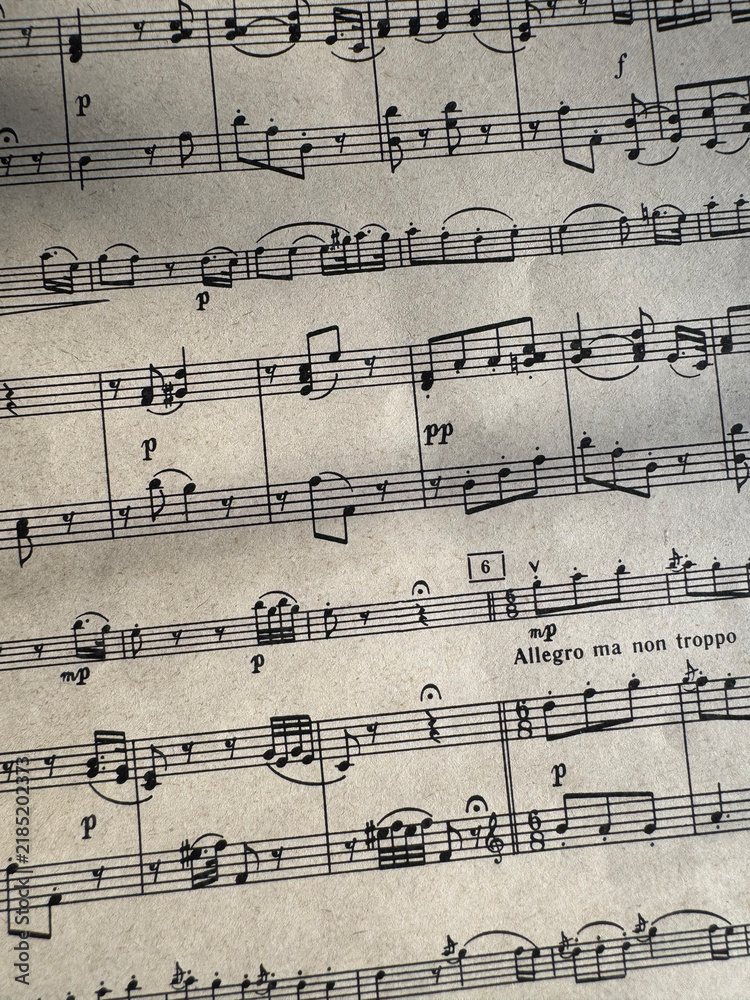 Fototapeta premium Close up of sheet music with musical notes and textured paper. Musical notes on sheet music, clear details of composition. Black notes, musical score, sheet music, musical notation, classical music
