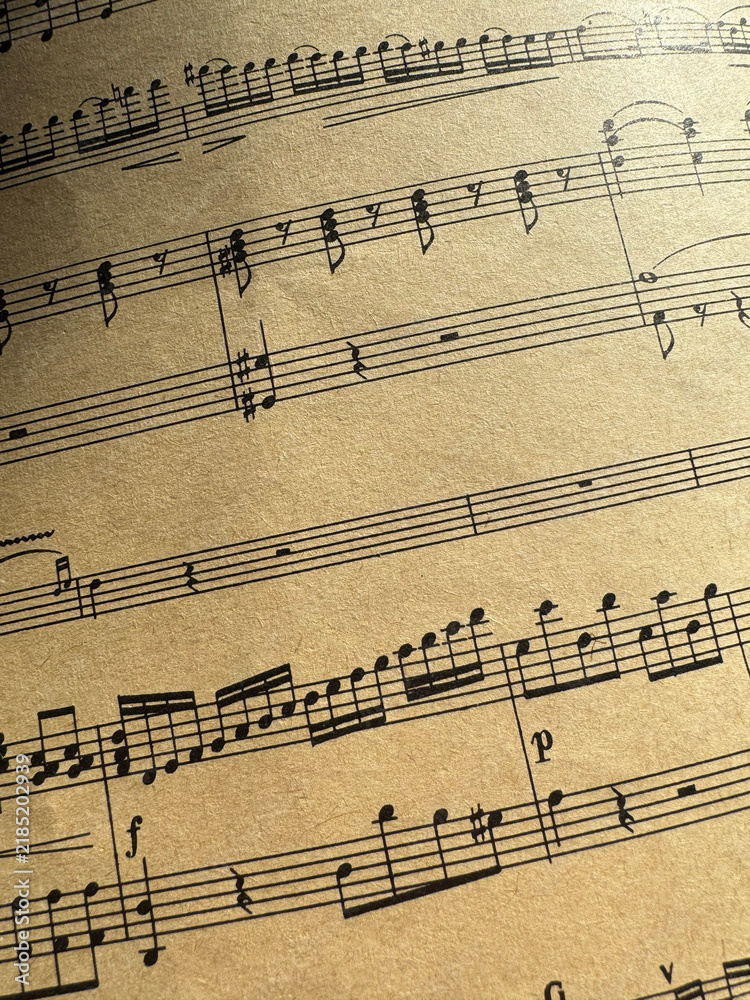 Fototapeta premium Close up of old sheet music with musical notes. Old musical score - no lyrics. Atmospheric music background with notes on old brown paper. For scrapbooking collage, journal design, and craft projects.