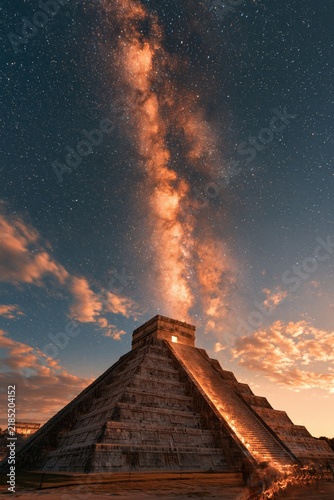 Chichen Itza pyramid during sunset with stars and clouds in the background