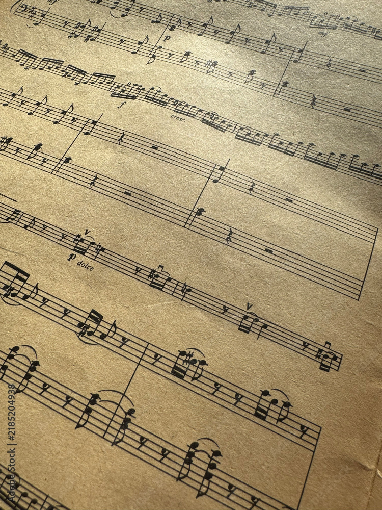 Fototapeta premium Close up of old sheet music with musical notes. Old musical score - no lyrics. Atmospheric music background with notes on old brown paper. For scrapbooking collage, journal design, and craft projects.