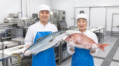 Naklejka 水産加工会社で鮮魚を持つ加工スタッフ