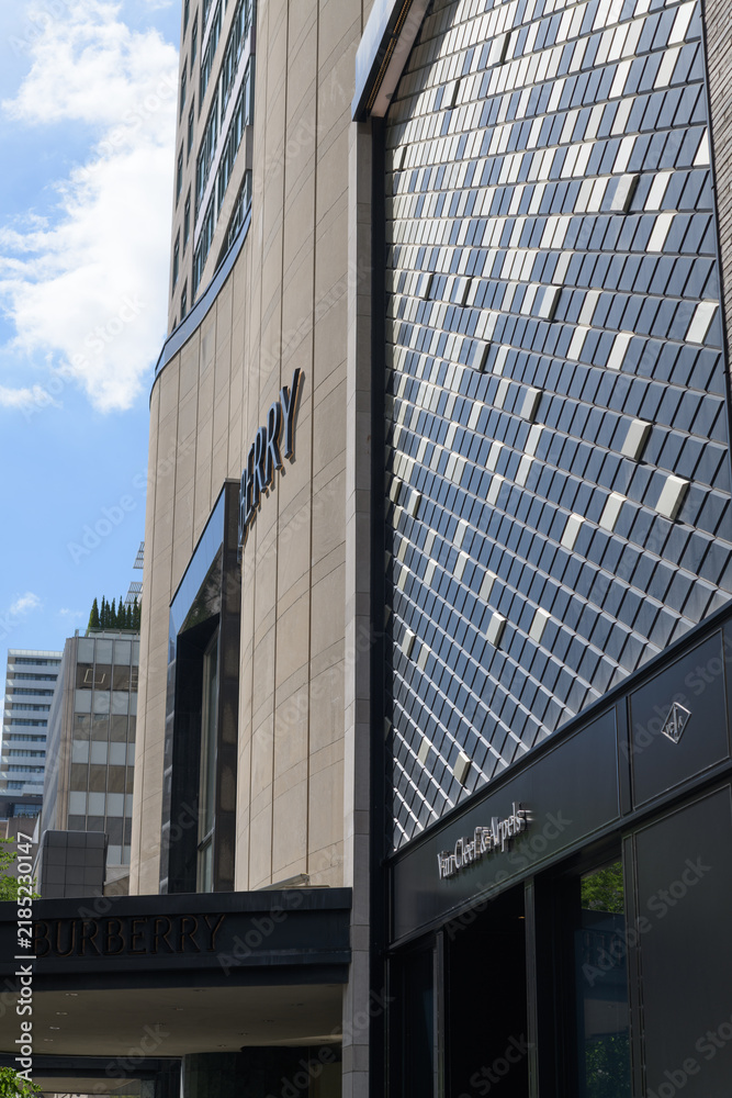 Fototapeta premium perspective view of exterior building facades and signs of Van Cleef & Arpels, a jewelry store, and Burberry, a clothing store, located at 100 Bloor St W, Toronto