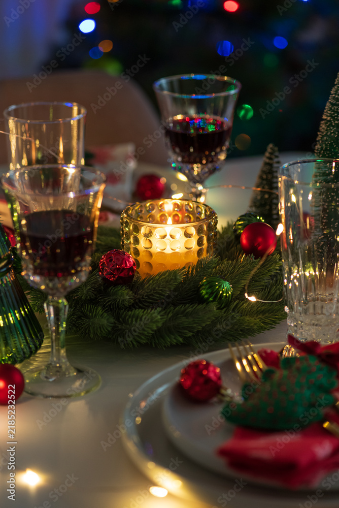 Obraz premium Cozy Christmas Eve Table Setting with Glowing Candle and Festive Decorations for a Family Gathering