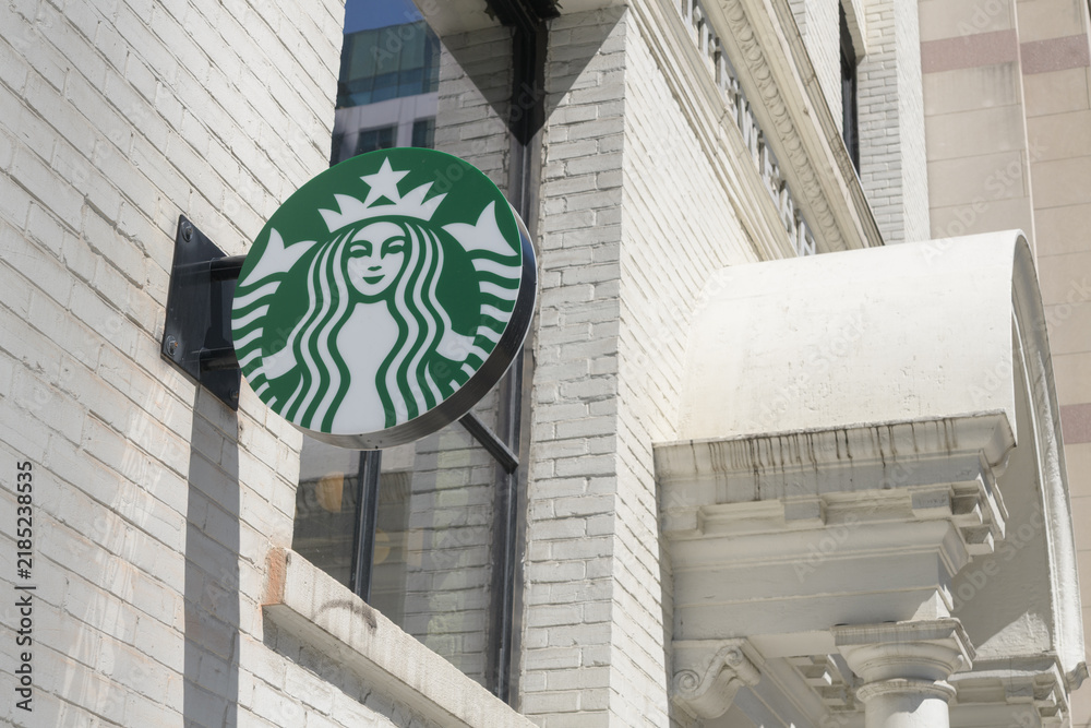 Obraz premium wall-mounted round projecting logo sign outside Starbucks coffee shop at the historic Eclipse Whitewear Building, 322 King St W, Toronto
