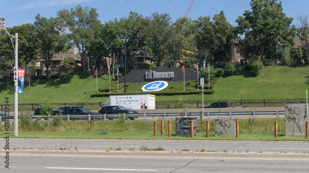 Obraz premium wide distant view of cars on the Gardiner Expressway and Toronto sign with logo - seen from about 1491 Lake Shore Blvd W