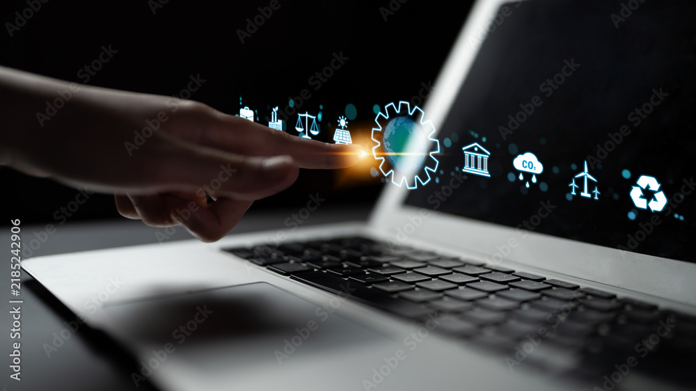 Obraz premium Futuristic Technology Concept with a Hand Interacting with Virtual Interface Icons on a Laptop Keyboard in a Dark Environment. Sentient.