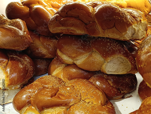 Market stall display with traditional challah bread, braided Shabbat loaves, and Jewish egg bread for sale.