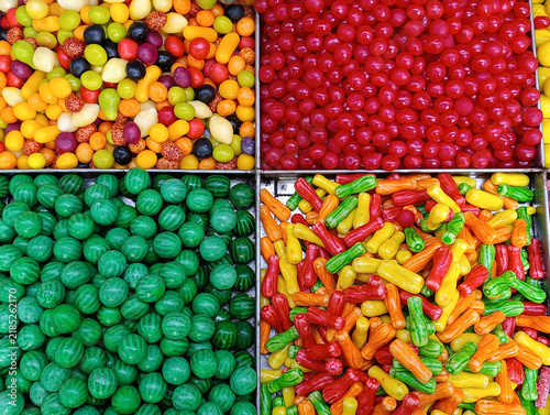 Bulk candy stall at a market shop, colorful loose sweets, gummy candies, sugar snacks, jelly candy and pick-and-mix treats displayed for sale by weight.
