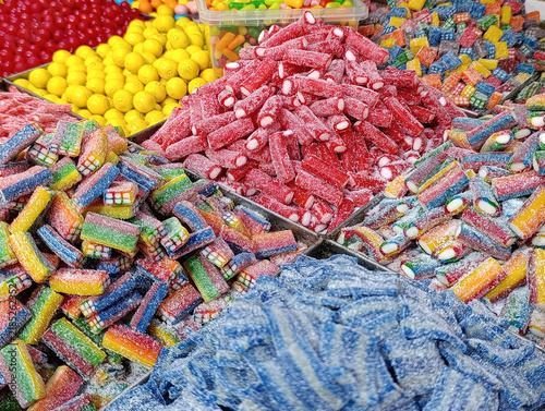 Bulk candy stall at a market shop, colorful loose sweets, gummy candies, sugar snacks, jelly candy and pick-and-mix treats displayed for sale by weight.